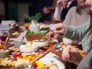 Close-up of a charcuterie board with cheeses, fruits, cured meats, and snacks on wooden boards